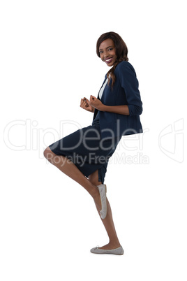 Side view of businesswoman standing on one leg