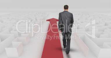 Businessman following red arrow walking through maze