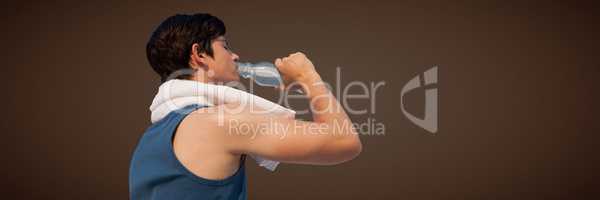 Back of man in training gear drinking water against brown background