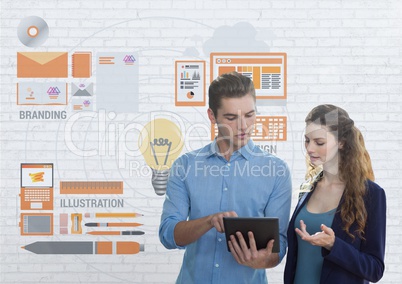 Business people looking at a tablet  against white wall with graphics