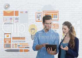 Business people looking at a tablet  against white wall with graphics