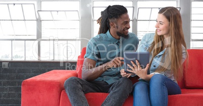 Students looking at tablet in front of windows background