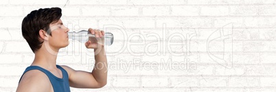 Man in training gear drinking water against white brick wall