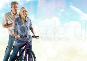 Couple on bicycle against cloudy sky