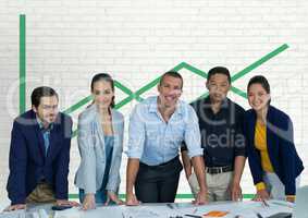 Happy business people at a desk standing against white wall with green graphic