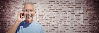 Elderly man on phone against purple brick wall