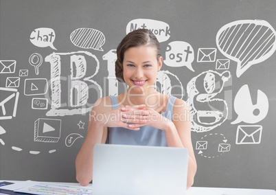Happy business woman at a desk  using a computer against grey background with graphics