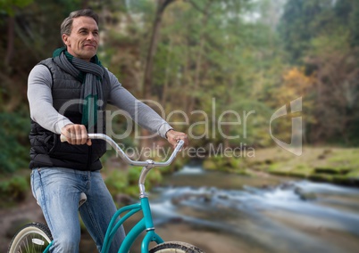 Man on bicycle against forest river