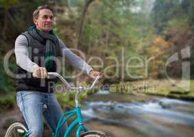 Man on bicycle against forest river