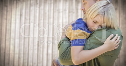 Father and son hugging against blurry wood panel