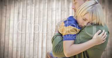 Father and son hugging against blurry wood panel