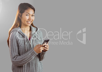 Portrait of woman holding phone with grey background