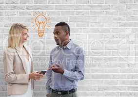 Happy business people talking against white wall with bulb graphic