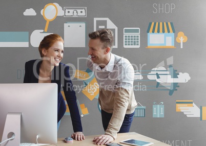 Happy business people at a desk using a computer against grey background with graphics