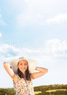 Millennial woman relaxing in sun hat against hills and Summer sky