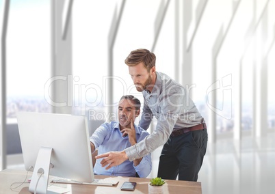 Business men at a desk pointing at a computer