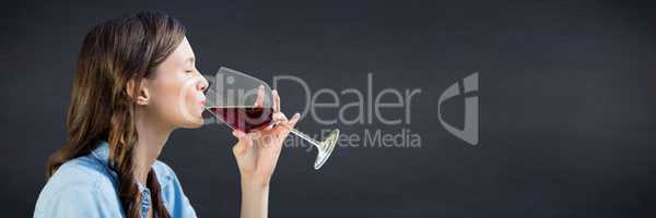 Woman tasting wine against navy chalkboard