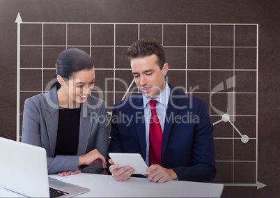 Happy business people at a desk looking at a tablet against brown background with graphic