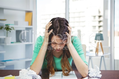 Frustrated business woman at a desk looking down