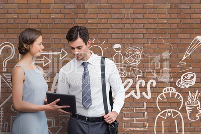 Business people looking at a tablet against brick wall with graphics