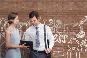 Business people looking at a tablet against brick wall with graphics