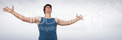 Low angle of man in training gear with arms out against white wall