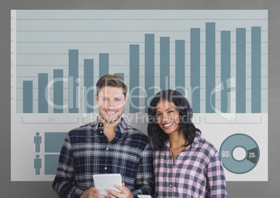 Happy business people holding a tablet against grey background with graphics