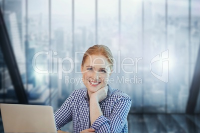 Happy business woman at a desk using a computer