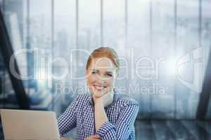 Happy business woman at a desk using a computer