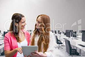 Happy business women using a tablet