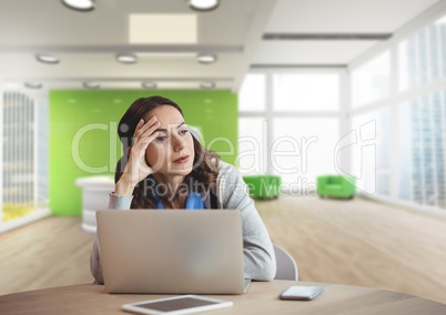 Worried business woman at a desk using a computer