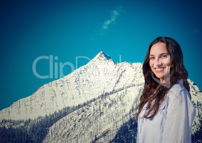 Millennial woman smiling against snowy mountain