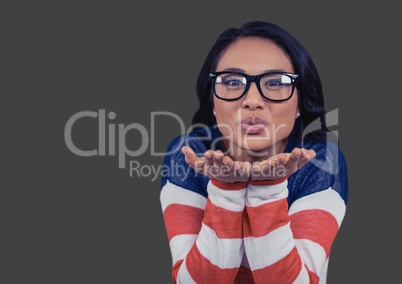 Portrait of woman blowing kisses with glasses with grey background