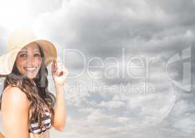 Millennial woman in sun hat against cloudy sky with flare