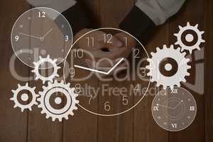 Gears and clock icons against hands on a table photo