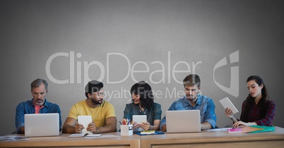 Group of people on devices in front of grey background