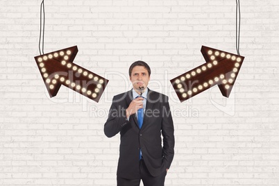 Confused business man standing against white wall with arrows