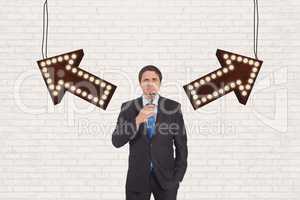Confused business man standing against white wall with arrows