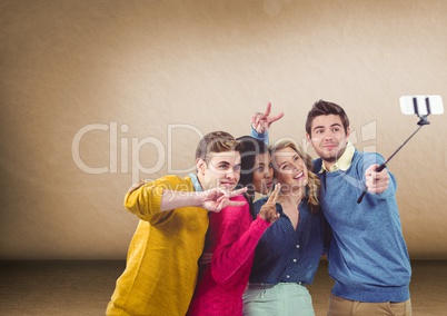 Group of friends taking selfie in front of blank brown background