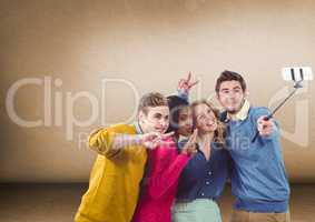 Group of friends taking selfie in front of blank brown background