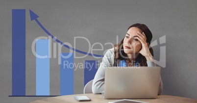 Worried business woman at a desk using a computer against grey background with blue graphics