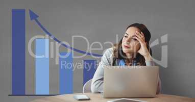 Worried business woman at a desk using a computer against grey background with blue graphics