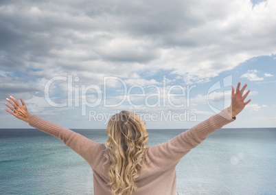 Woman with open arms practicing casual mindfulness in front of sea