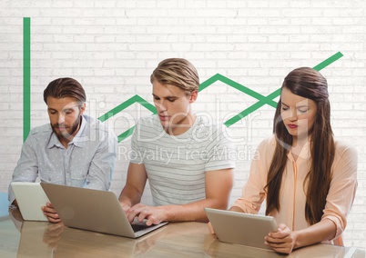 Business people at a desk looking at a tablet and a computer against white wall with green graphics