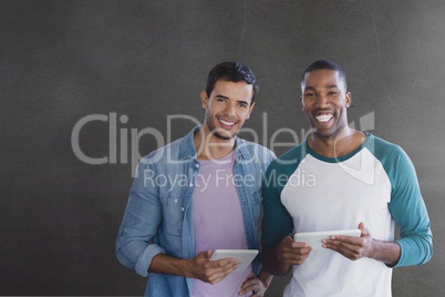 Happy business men holding a tablet against grey background