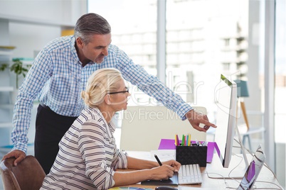 Business people at a desk looking at a computer