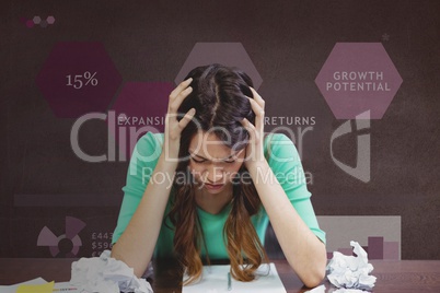 Frustrated business woman at a desk looking down against purple background with graphics