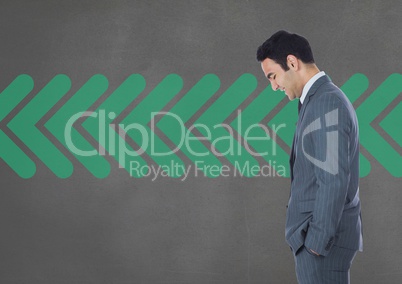 Business man standing against grey background with green arrows