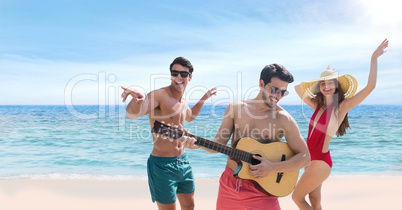 People at the beach playing guitar and dancing