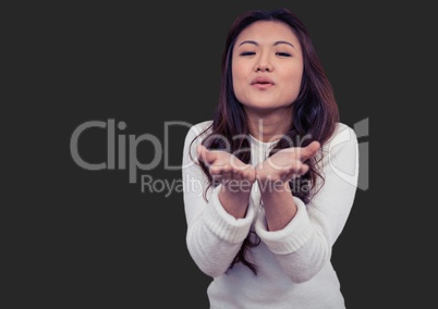 Portrait of woman blowing kisses with grey background